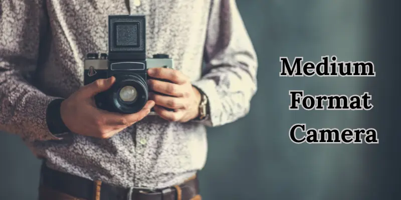 Photographer Holding A Medium Format Camera, Known For High-Resolution, Professional-Grade Photography.