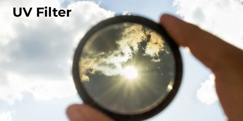 Uv Filter Held Up To The Sky, Protecting Against Harmful Uv Rays While Improving Clarity In Outdoor Photography.