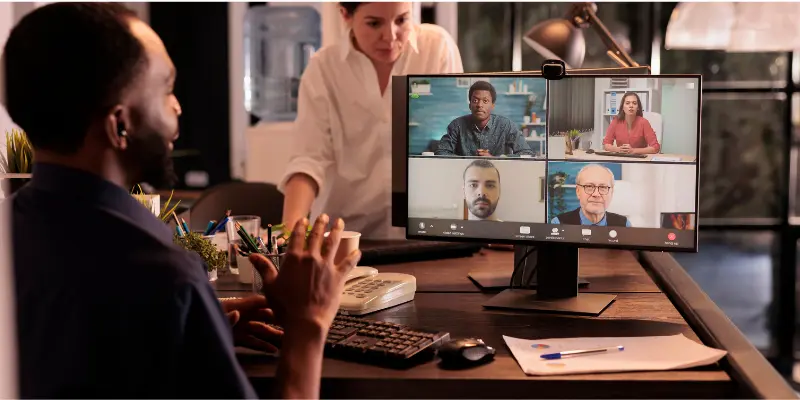 Video Conference With Multiple Participants On Screen, Showing A Professional Meeting Setup.